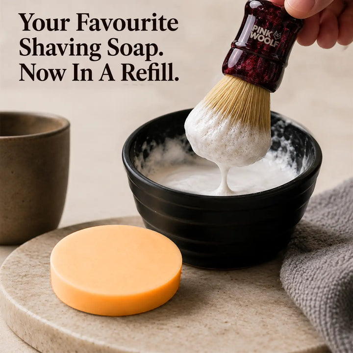 Pink Woolf shaving soap refill being used with a shaving brush to create rich lather
