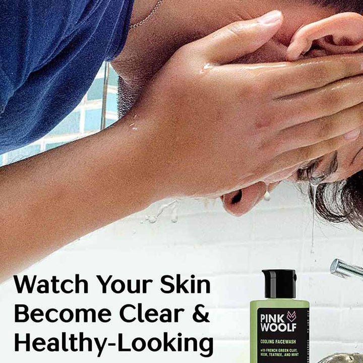 Sean washing face with a bottle of Pink Wolf neem french green clay face wash skincare product in the foreground.