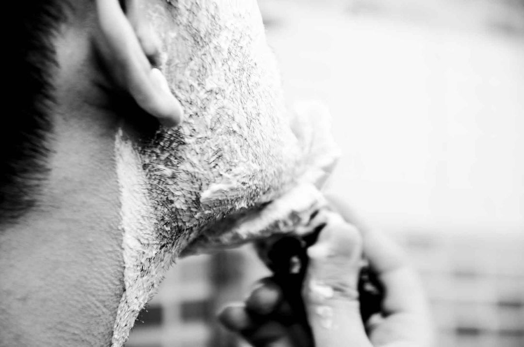 Close-up of a traditional wet shave using a double edge safety razor over rich shaving lather.